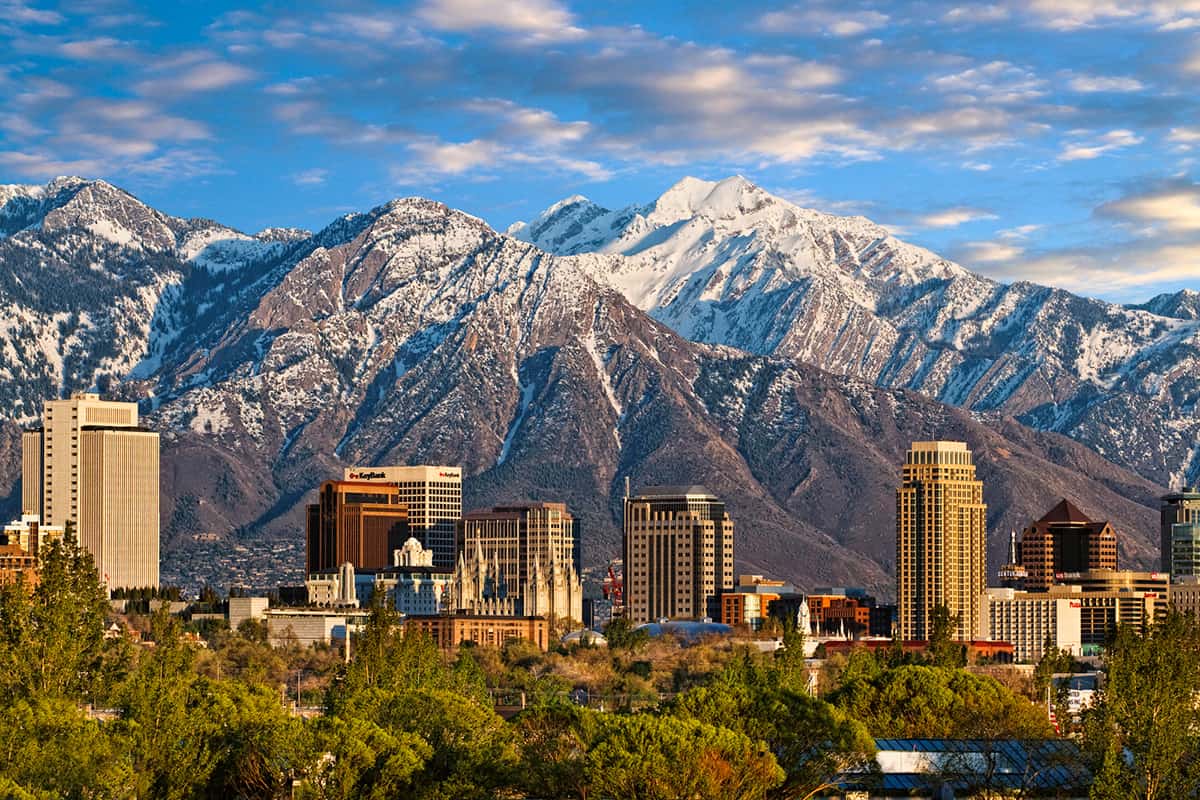The Salt Lake City skyline with the snow-capped Wasatch Mountains rising behind it.